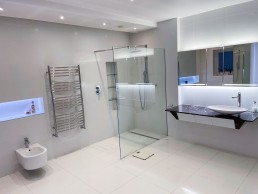 White modern bathroom with marble sink, bidet, glass shower and good lighting. Location hire for TV and filming in Park Lodge, London