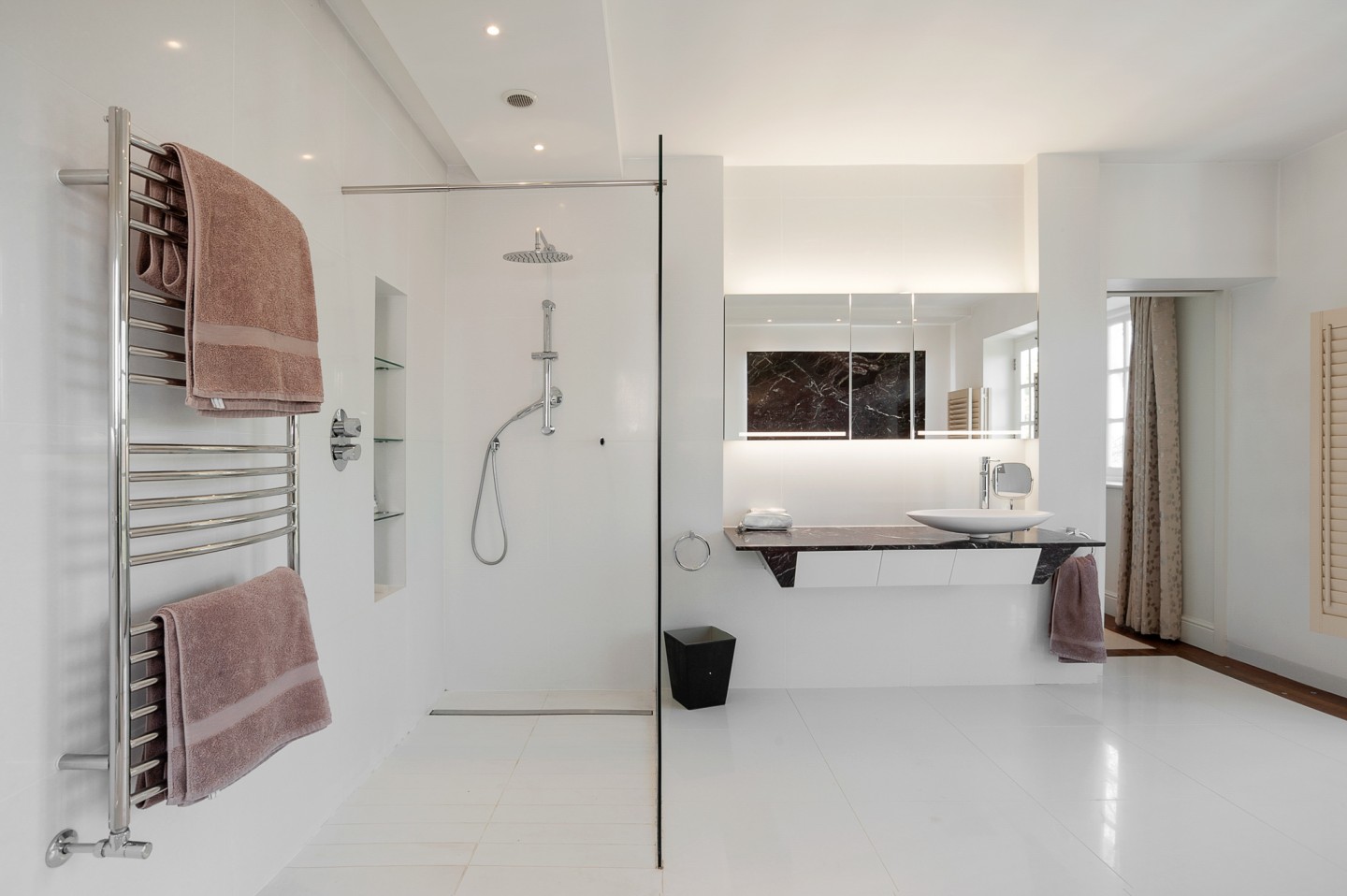 White modern bathroom with marble sink, bidet, glass shower and good lighting. Location hire for TV and filming in Park Lodge, London