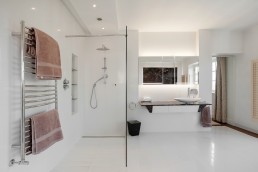 White modern bathroom with marble sink, bidet, glass shower and good lighting. Location hire for TV and filming in Park Lodge, London
