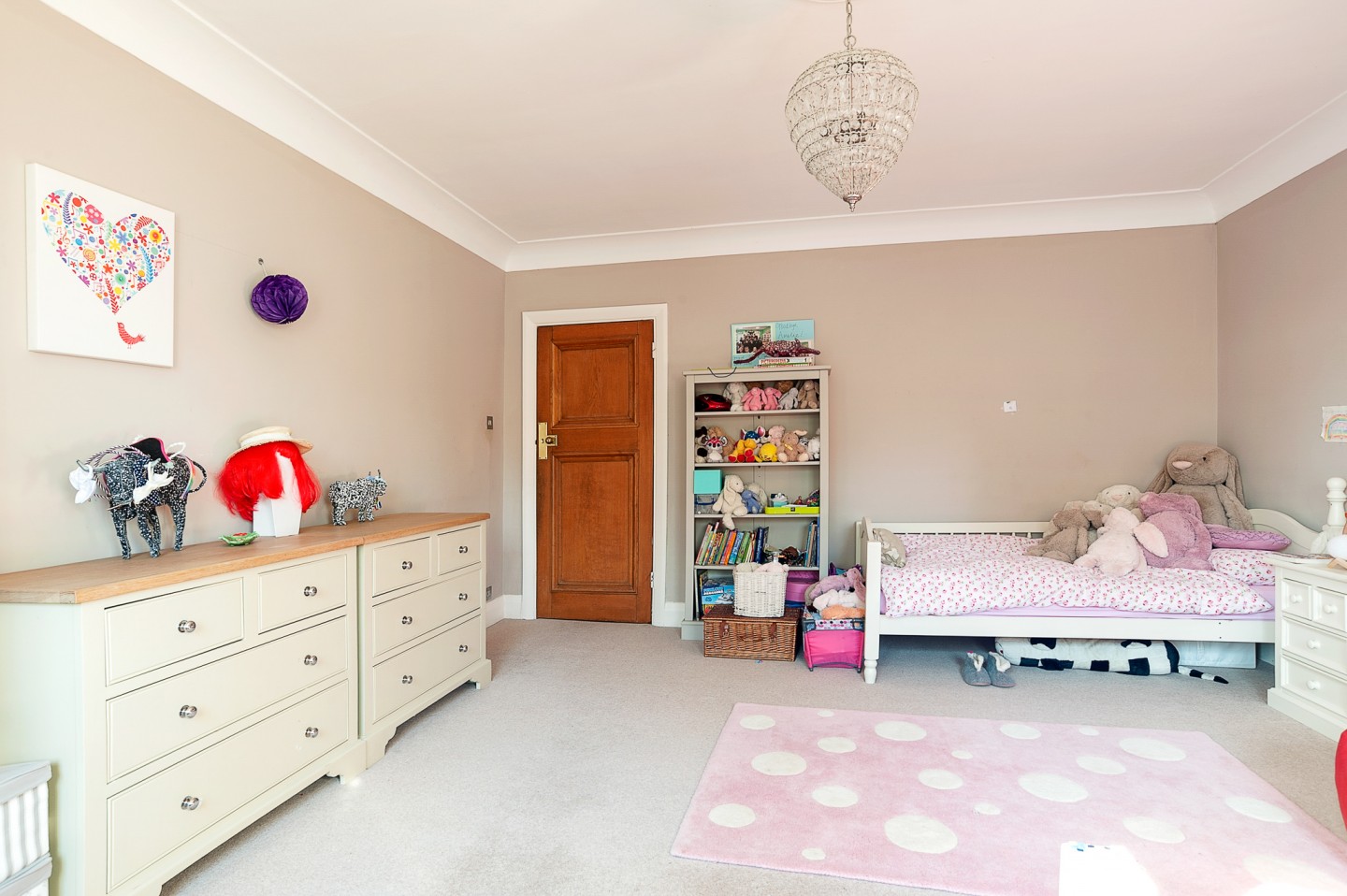 Pre teen girl's bedroom neptune styled with large space, wood door, soft toys, bookshelves, drawers and girly decor. Location hire for TV and filming in Park Lodge, London