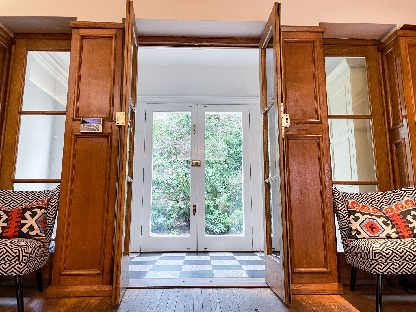 Entrance hall with large acorn glass doors with wood panels. Location hire for TV and filming in Park Lodge, London