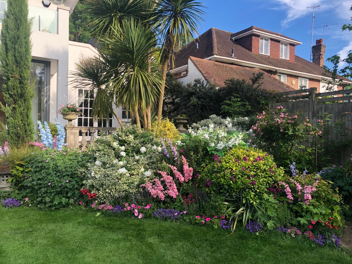 Garden palm trees with planters, trees and flower pots. Location hire for TV and filming in Park Lodge, London