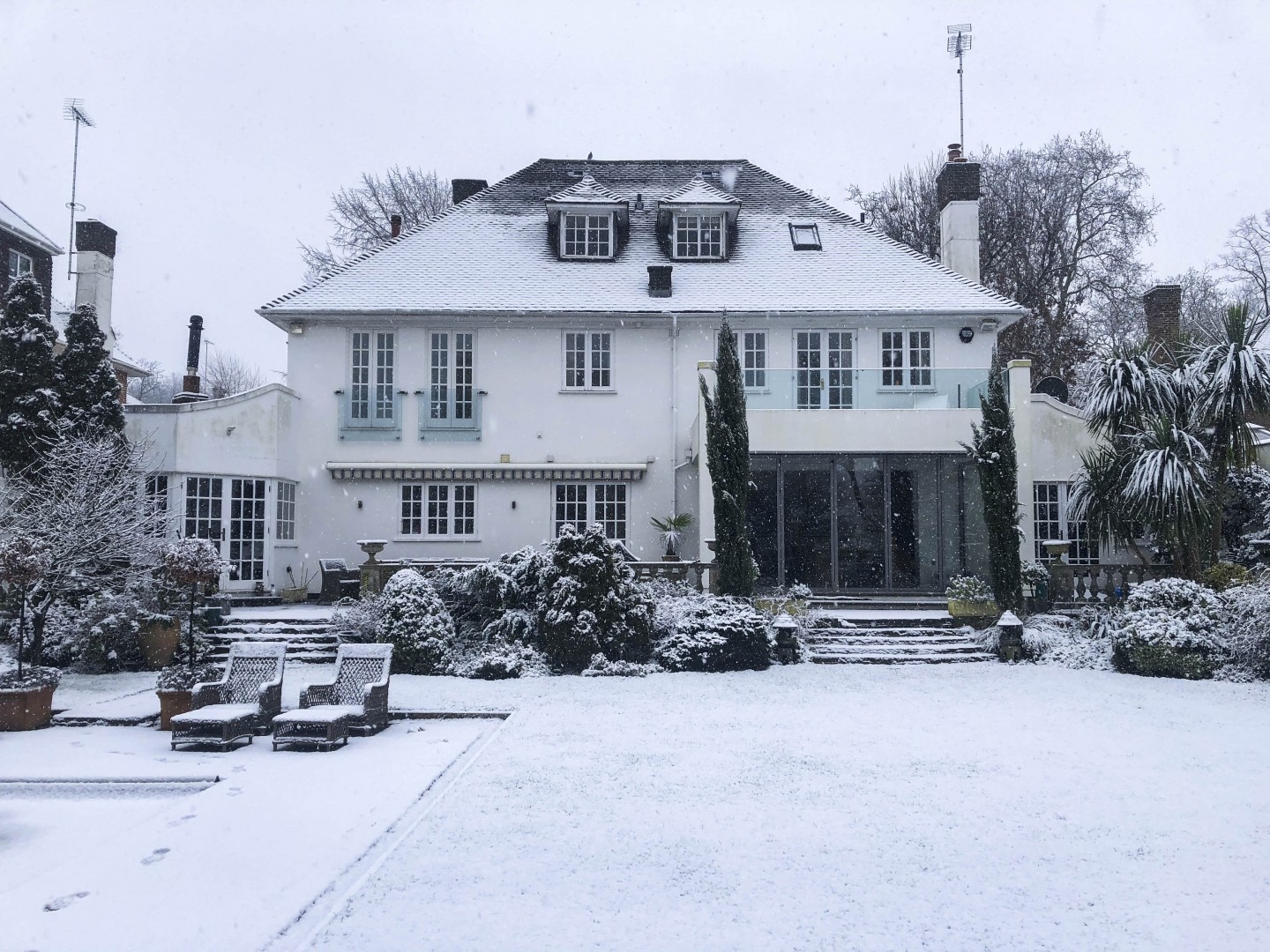 Beautiful rear garden in winter, trees covered in snow. Location hire for TV and filming in Park Lodge, London