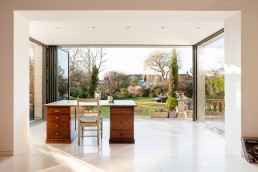 Sitting room with a garden view, glass door, work table and marble floor. Location hire for TV and filming in Park Lodge, London