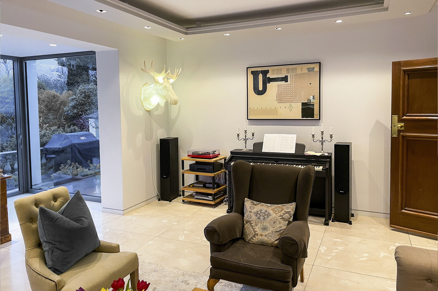 Sitting room with a garden view, glass door, work table and marble floor. Location hire for TV and filming in Park Lodge, London