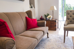 Sitting room with a garden view, modern art on wall, beige sofa and chairs. Location hire for TV and filming in Park Lodge, London