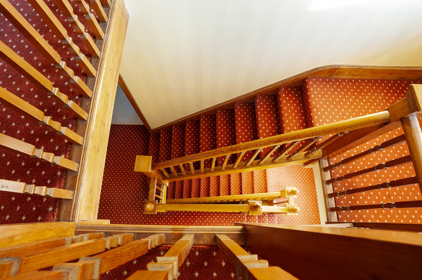 Staircase bannister with oak panels and acorn windows in bright lighting. Location hire for TV and filming in Park Lodge, London