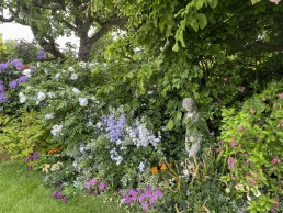 Garden statue with planters, trees and flower pots. Location hire for TV and filming in Park Lodge, London