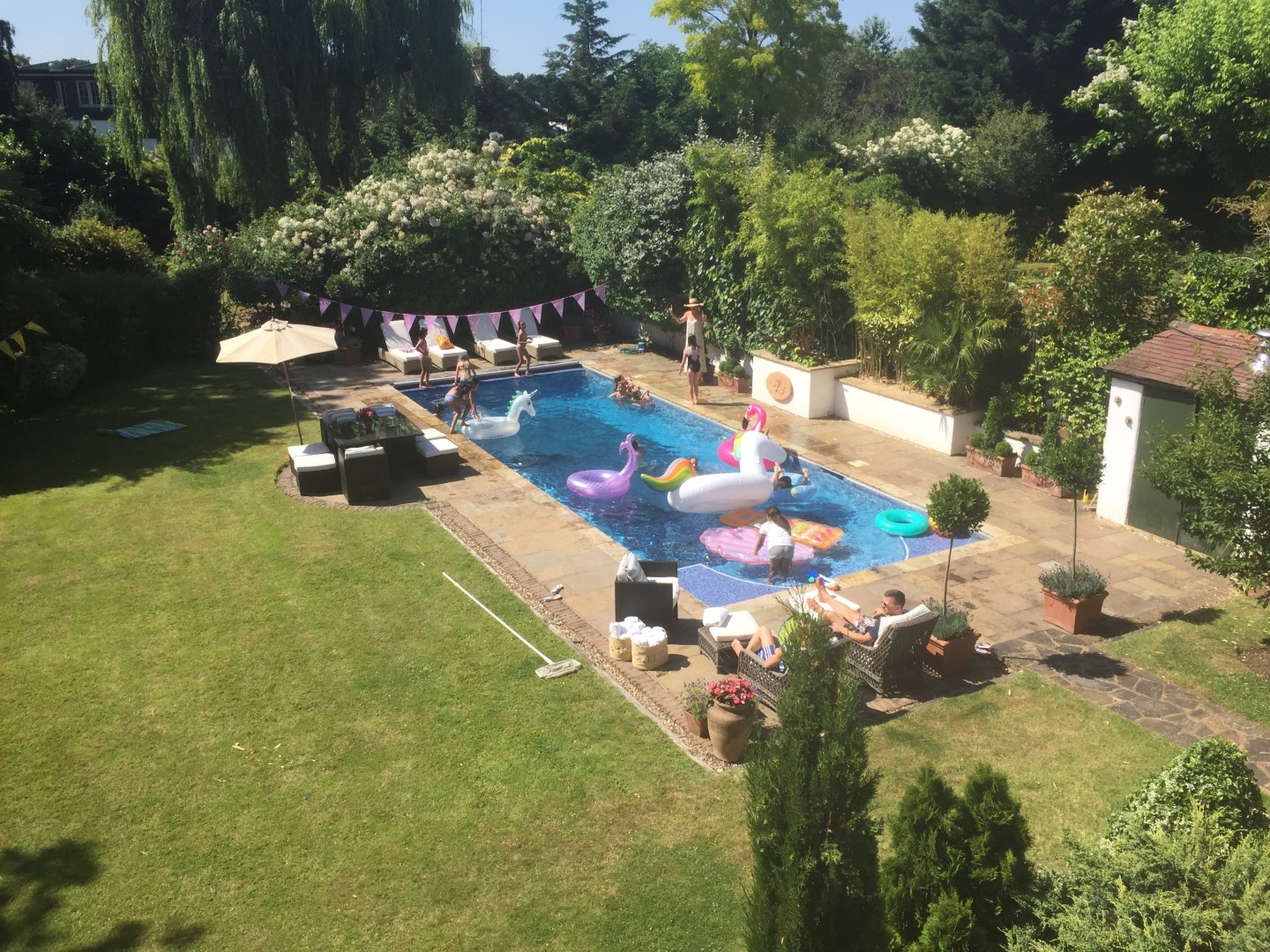 Garden with planters, swimming pool, trees flowers and outdoor furniture. Location hire for TV and filming in Park Lodge, London