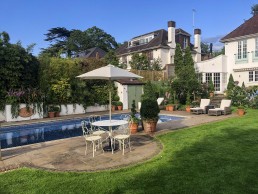 Terracotta garden with planters, swimming pool, outdoor furniture and trees. Location hire for TV and filming in Park Lodge, London