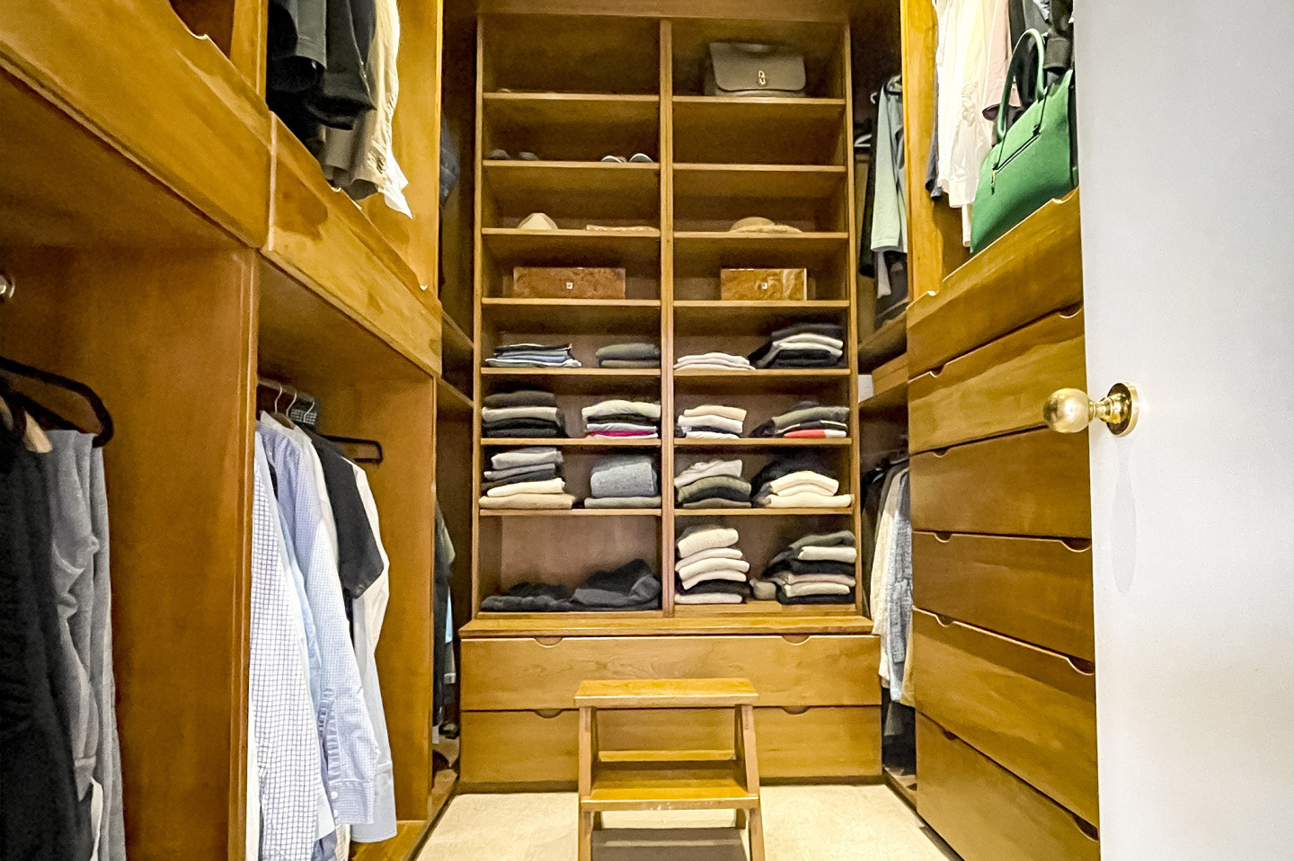 Walk in wardrobe made of classic oak panels. Hangers, shelves and drawers for shoes and clothes. Location hire for TV and filming in Park Lodge, London