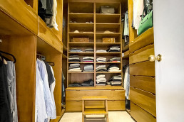 Walk in wardrobe made of classic oak panels. Hangers, shelves and drawers for shoes and clothes. Location hire for TV and filming in Park Lodge, London